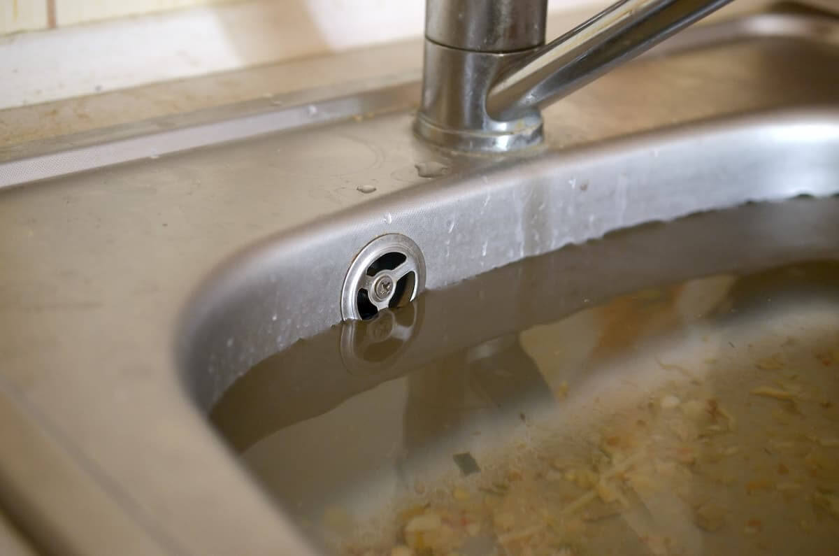 不锈钢厨房水槽充满了从堵塞的肮脏的站立水